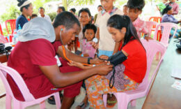 Student taking a child's blood pressure during a Mercer On Mission Cambodia trip