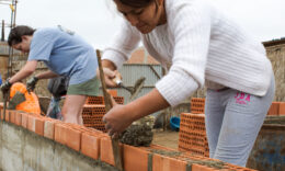 close up of a student laying bricks at a worksite