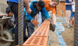 Studnets laying bricks at a worksite