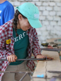 Mercer student working with a metal pipe