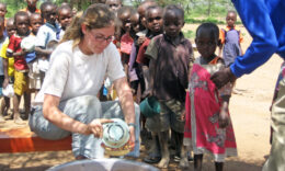 Student serving food to children