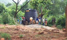 Kenyan locals installing a large water tank
