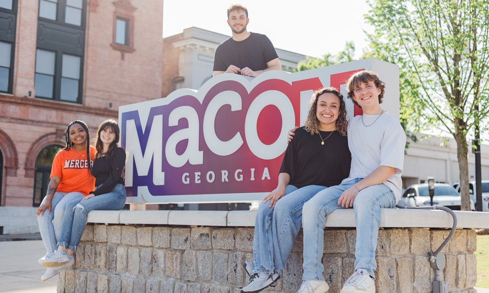 students posing with Macon sign downtown