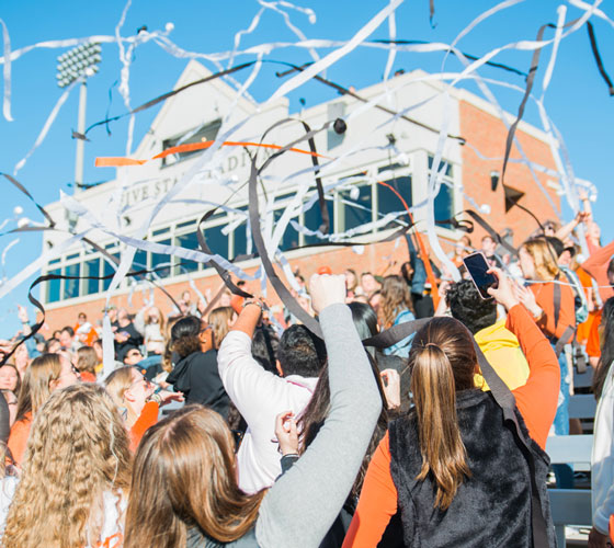 Students throwing streamers at a football game