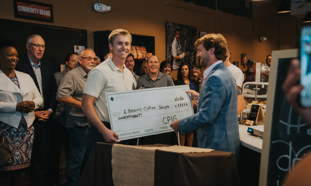 Shane Buerster being presented an investment check for the Z Beans coffee shop