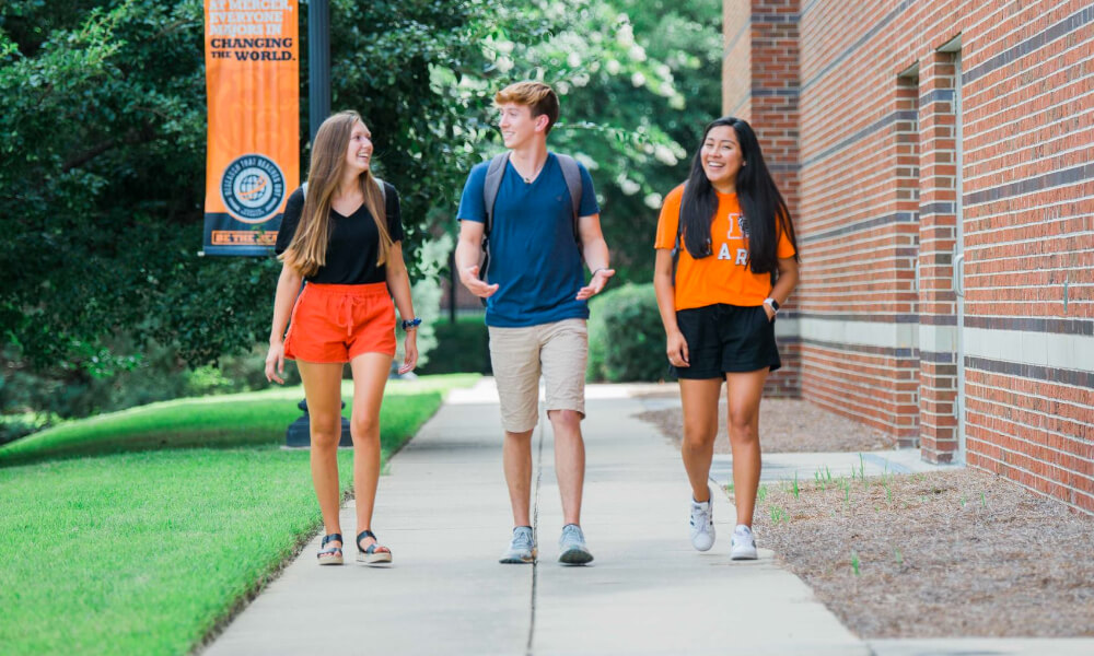 Three students walking on a sidewalk together