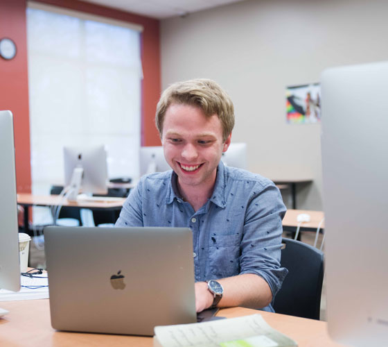 Student smiling while on computer
