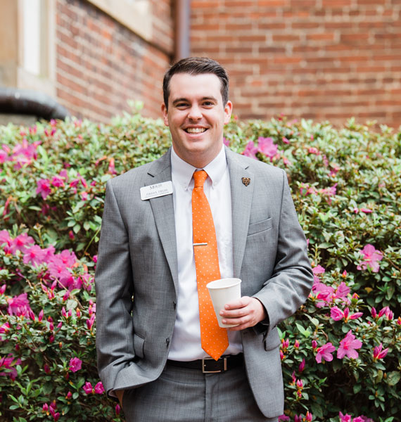 Jordan Fields smiling for a photo in front of flowers