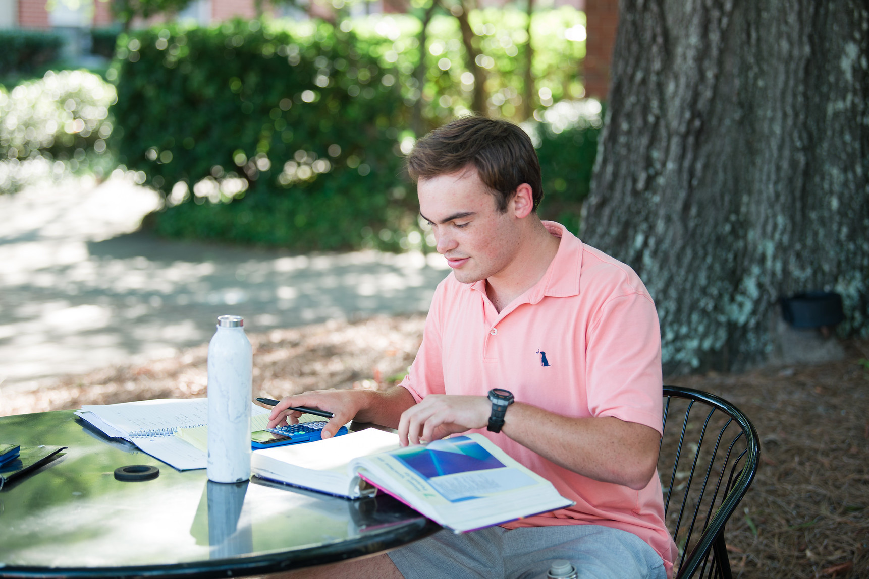 Photo of a student studying at a table outside