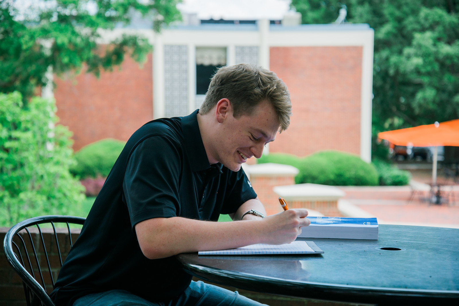 Photo of a student studying at a table outside