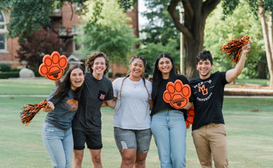 Students waving pom poms on historic quad