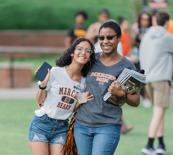 Mother and daughter wearing Mercer t-shirts, smiling at an admissions event.