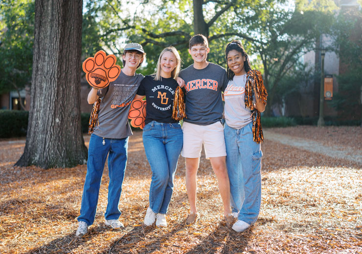 Mercer students smiling, wearing Mercer spirited gear.